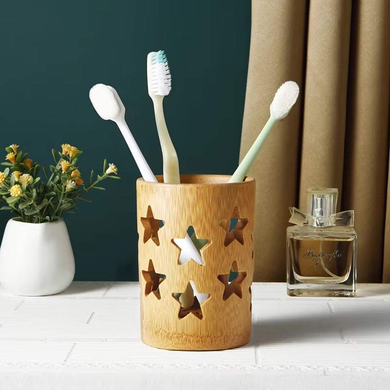 Bamboo toothbrush organizer with star cutouts holding toothbrushes on bathroom countertop