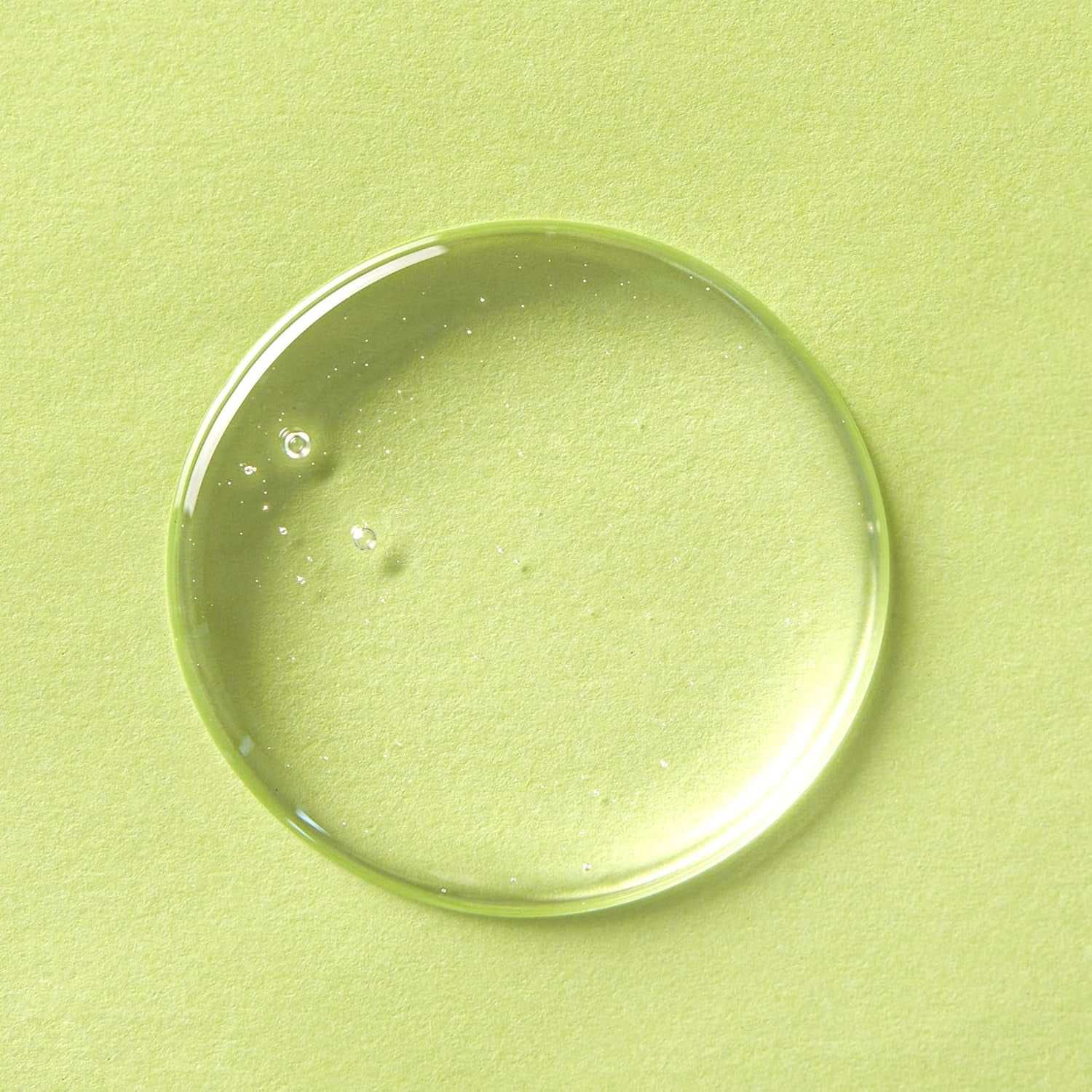 Clear drop of cleansing oil on light green background for facial cleanser product