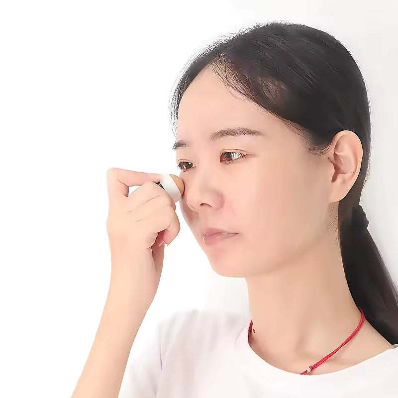 A person using a mini natural volcanic stone face roller for oil control and mattifying effect.