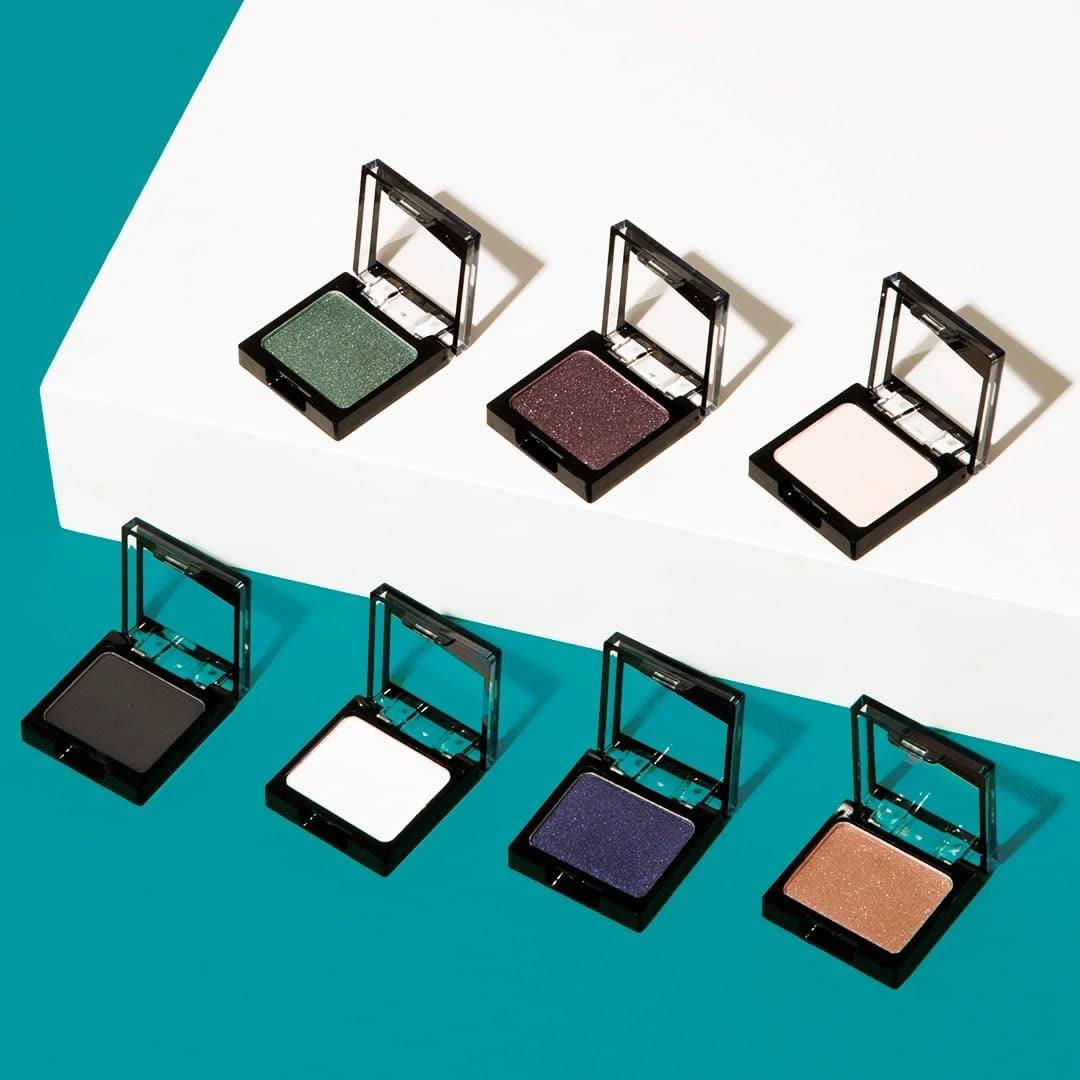 Ultra-pigmented eyeshadow collection with vibrant shades in black, white, green, purple, navy, brown, and beige tones in sleek black compact cases with mirrors.