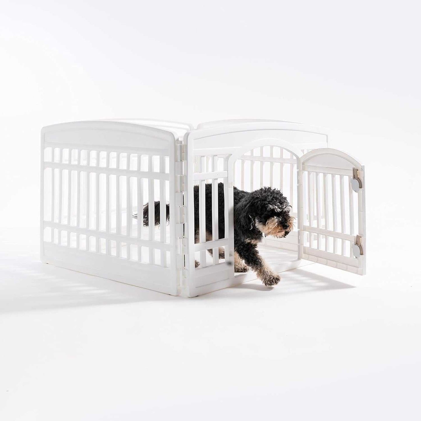 White pet exercise playpen door panel with a small black dog exiting through the open door, designed for secure and customizable puppy enclosures.