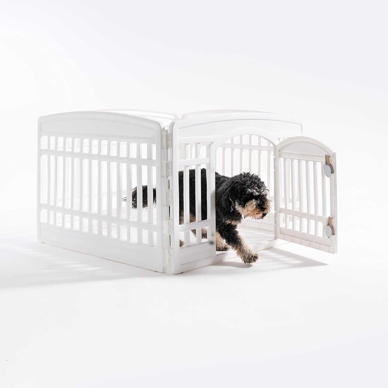 White pet exercise playpen door panel with a small black dog exiting through the open door, designed for secure and customizable puppy enclosures.