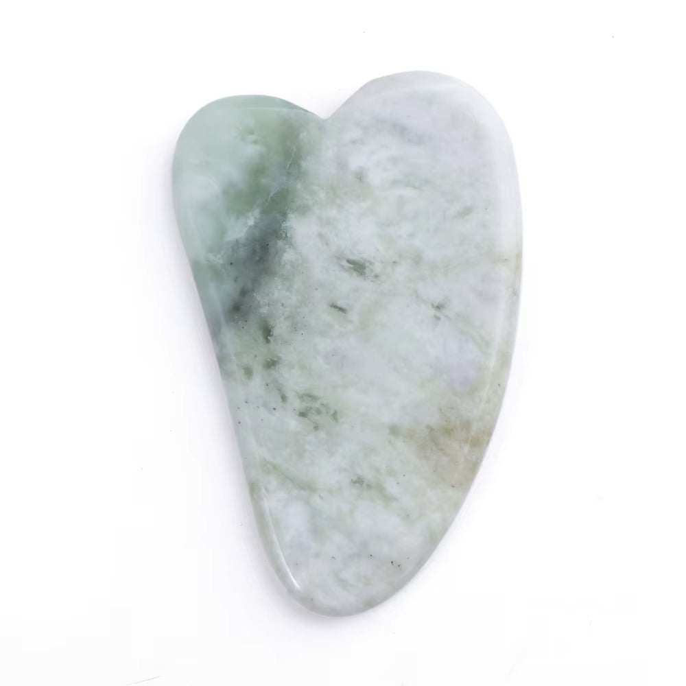 Natural jade gua sha tool for facial massage and skincare.