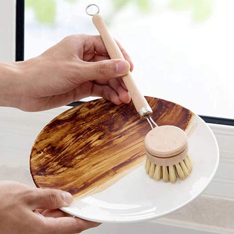 Bamboo cleaning brush scrubbing a dish, showcasing eco-friendly kitchen tool with natural handle and bristles.
