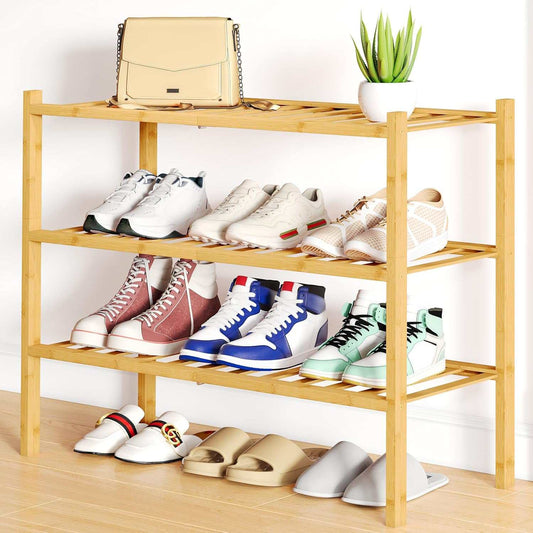 Stylish three-tier bamboo shoe rack with multiple shoes and bags in entryway.