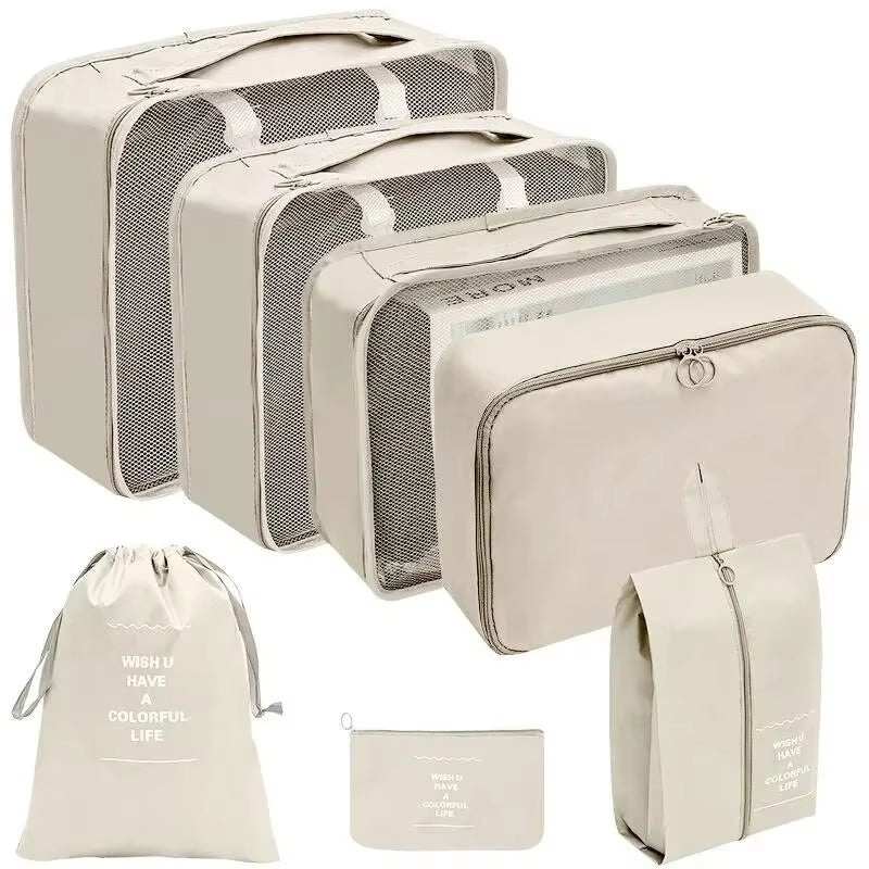 Travel organizer storage bag set with multiple sizes, including packing cubes, laundry bags, and pouches, in cream color.