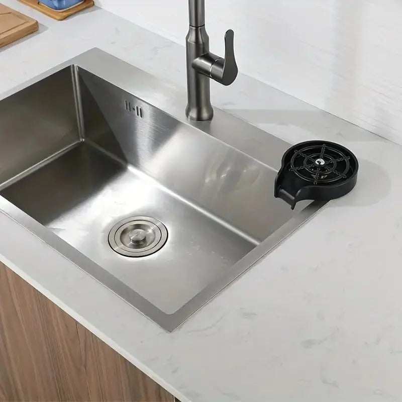 Sink-mounted high pressure automatic cup washer on a kitchen counter.