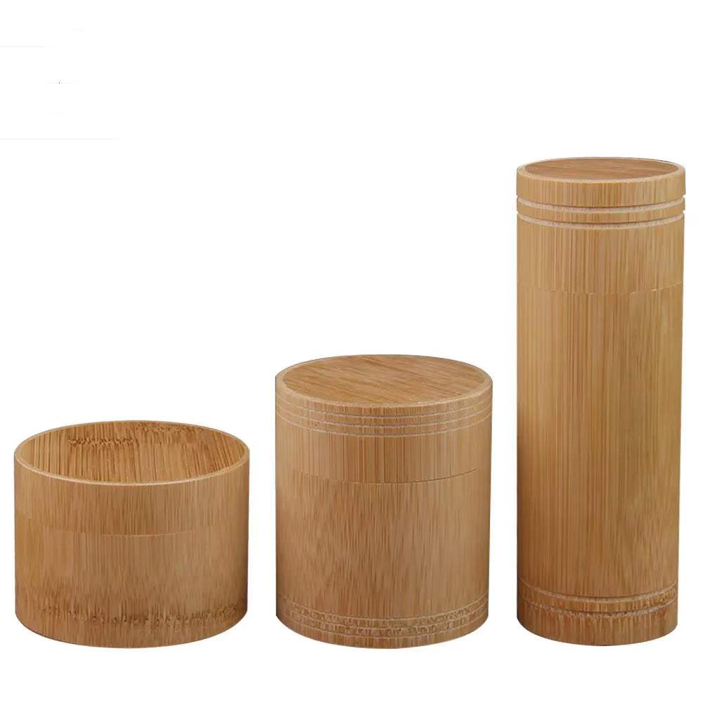 Set of three handmade bamboo storage boxes with cylindrical shapes and natural finish for kitchen organization and eco-friendly storage.