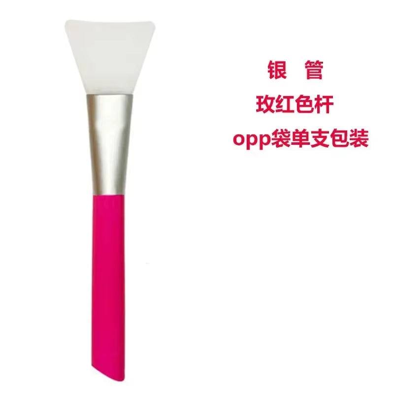 Silicone facial mask brush with a pink handle and soft white applicator, ideal for skincare mask application.