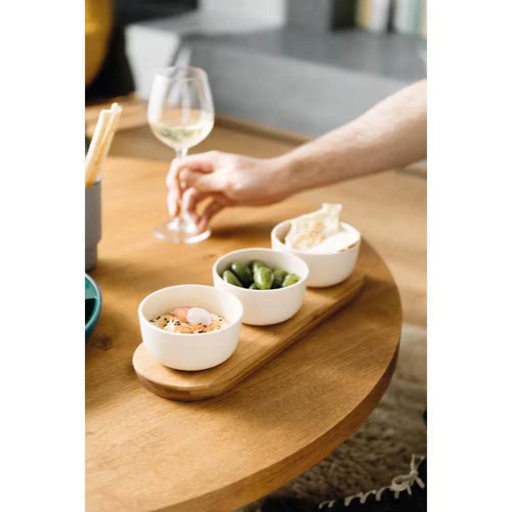 Bamboo Bowl Set on a table with snacks and a hand holding a wine glass in the background.