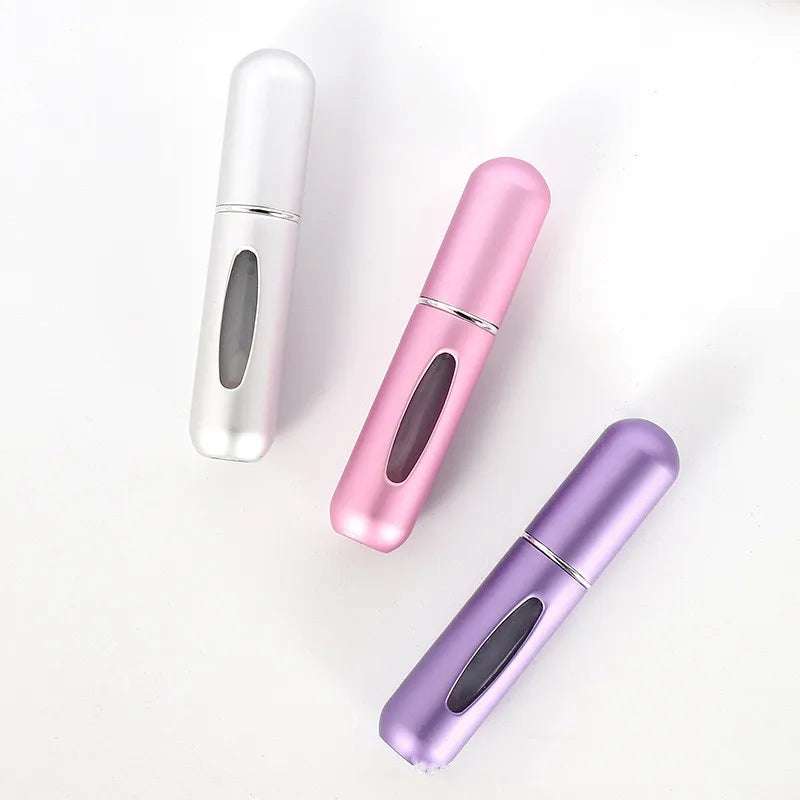 Portable 5ml refillable perfume atomizer bottles in silver, pink, and purple for travel and everyday use