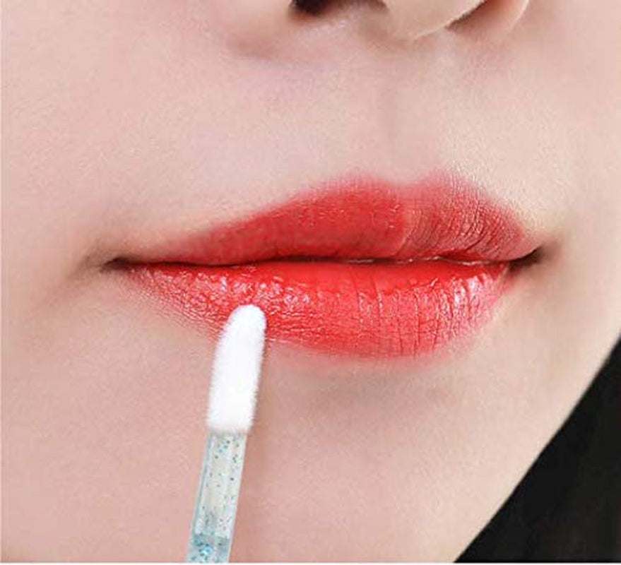 Disposable crystal lip brush applying lipstick for precise makeup application.