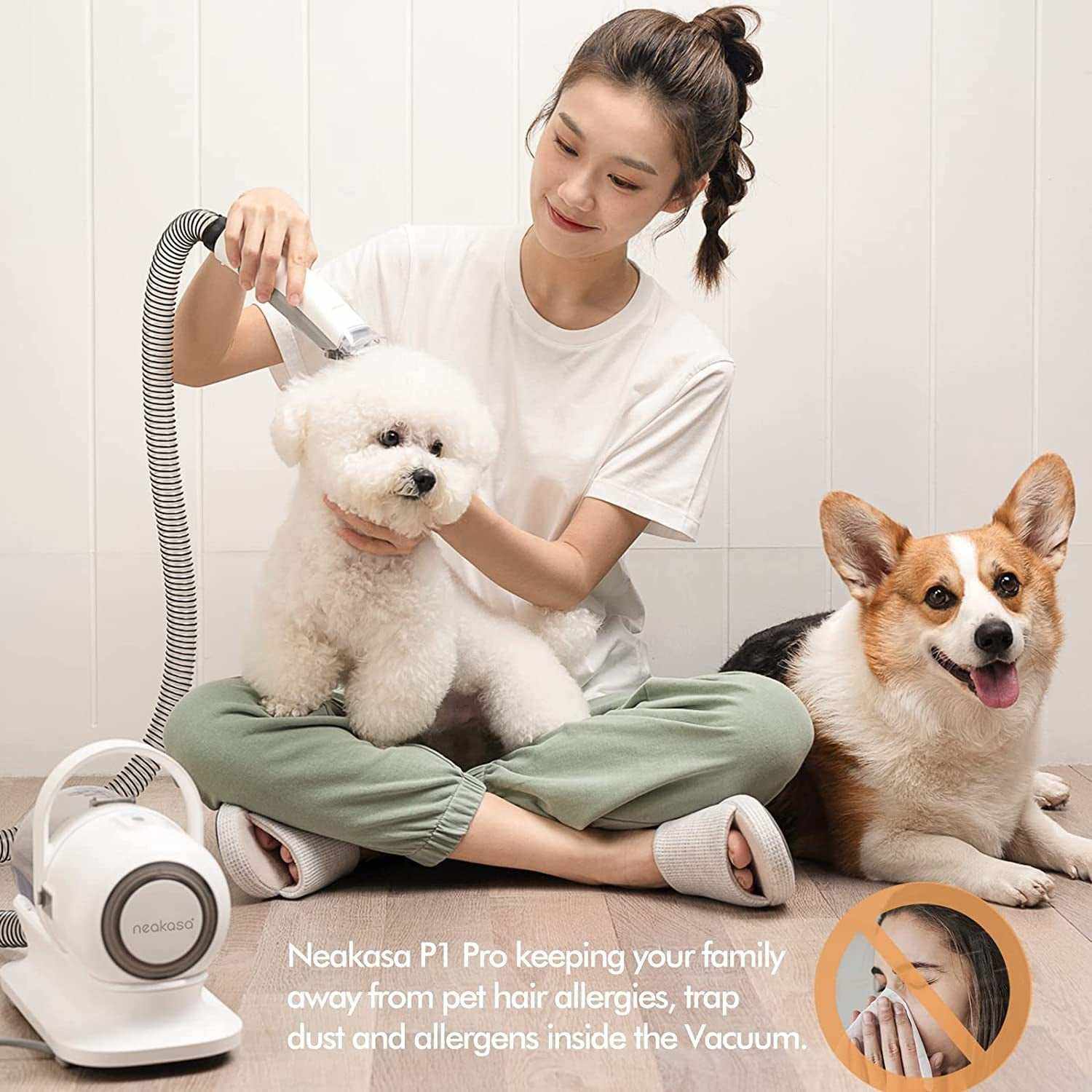 Woman grooming white fluffy dog with Neakasa P1 Pro pet grooming vacuum featuring powerful clippers and vacuum suction, with a brown corgi sitting nearby.