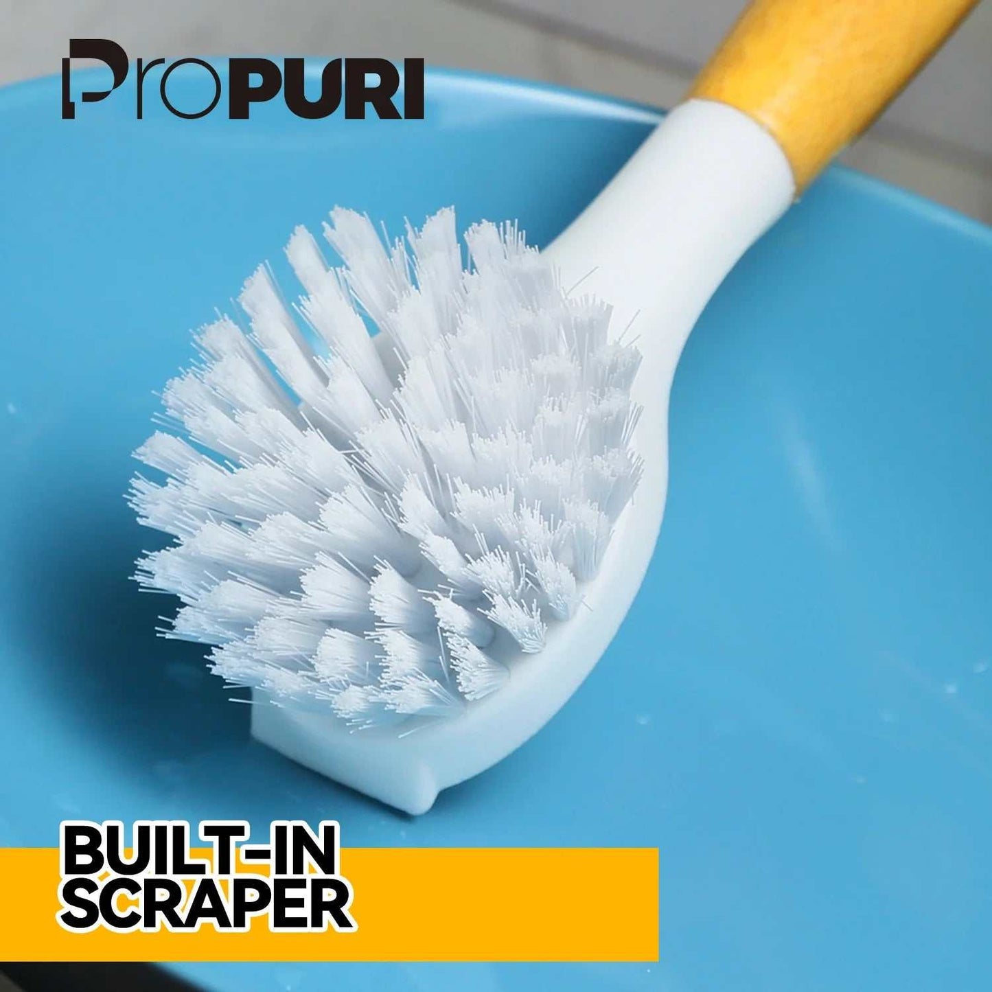 Bamboo handle dish brush with white bristles on a blue surface, featuring a built-in scraper.