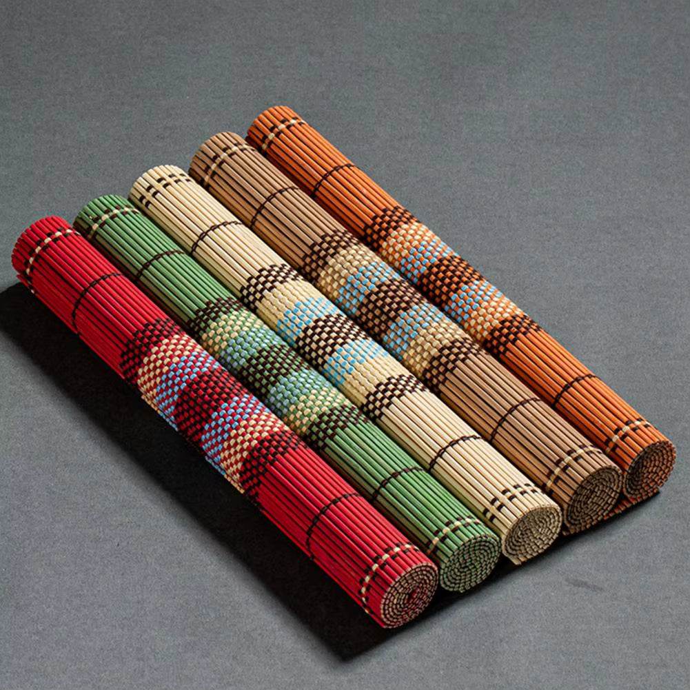 Set of colorful rolled decorative bamboo table mats, lightweight and waterproof for dining table protection and style.