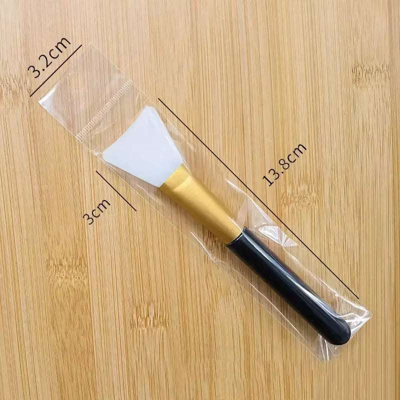 Silicone facial mask brush with soft white head and durable black handle, ideal for applying skincare products.