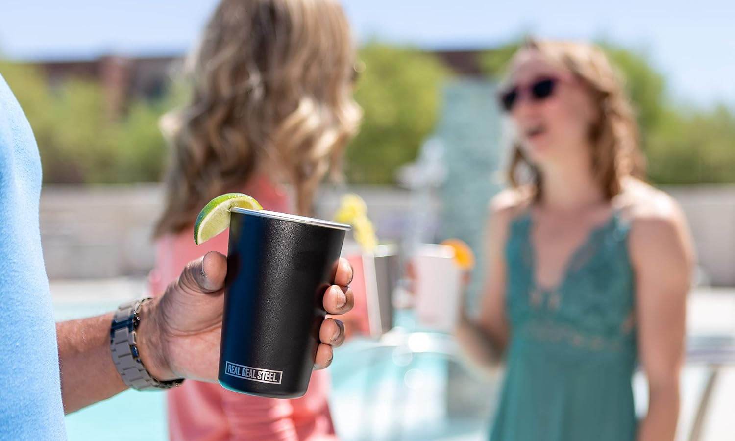 Eco-friendly premium metal drinking glass held by a person, ideal for outdoor gatherings.