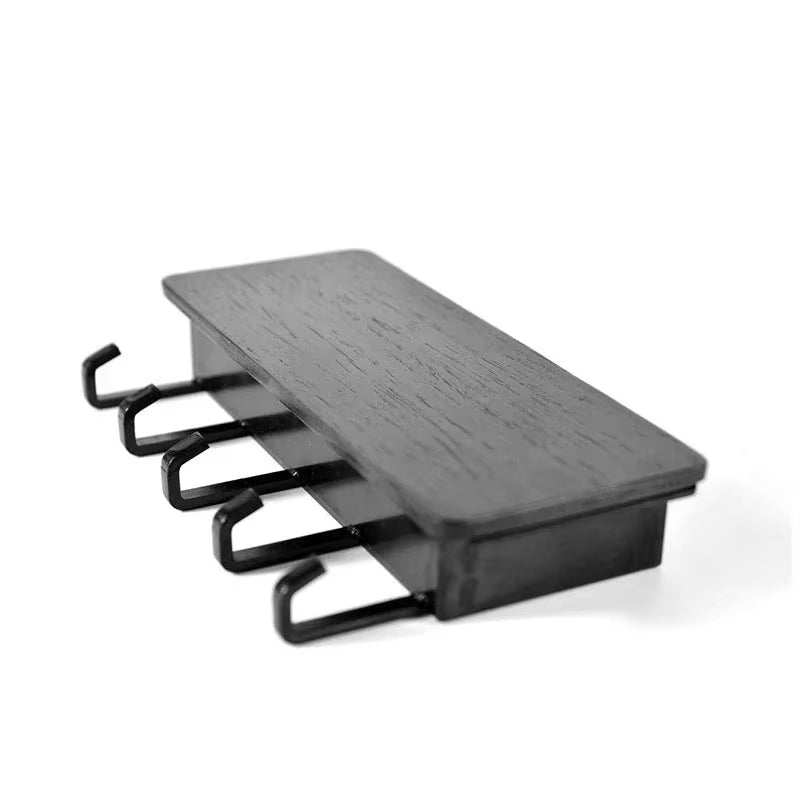 Compact wall-mounted bamboo key and coat hanger with hooks and a small shelf for home organization.