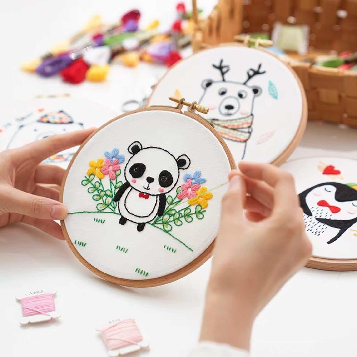 Embroidery project using pre-cut natural cotton fabric with cute animal designs in a hoop.