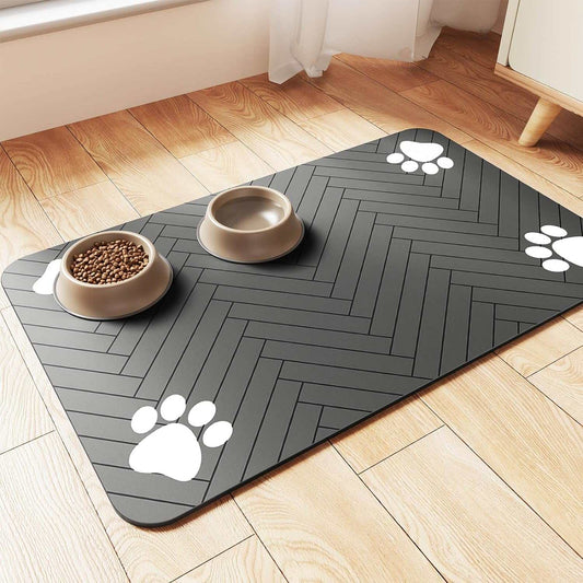 Pet waterproof feeding mat in dark gray with paw prints, non-slip and quick-dry surface, holding pet food and water bowls on wooden floor.