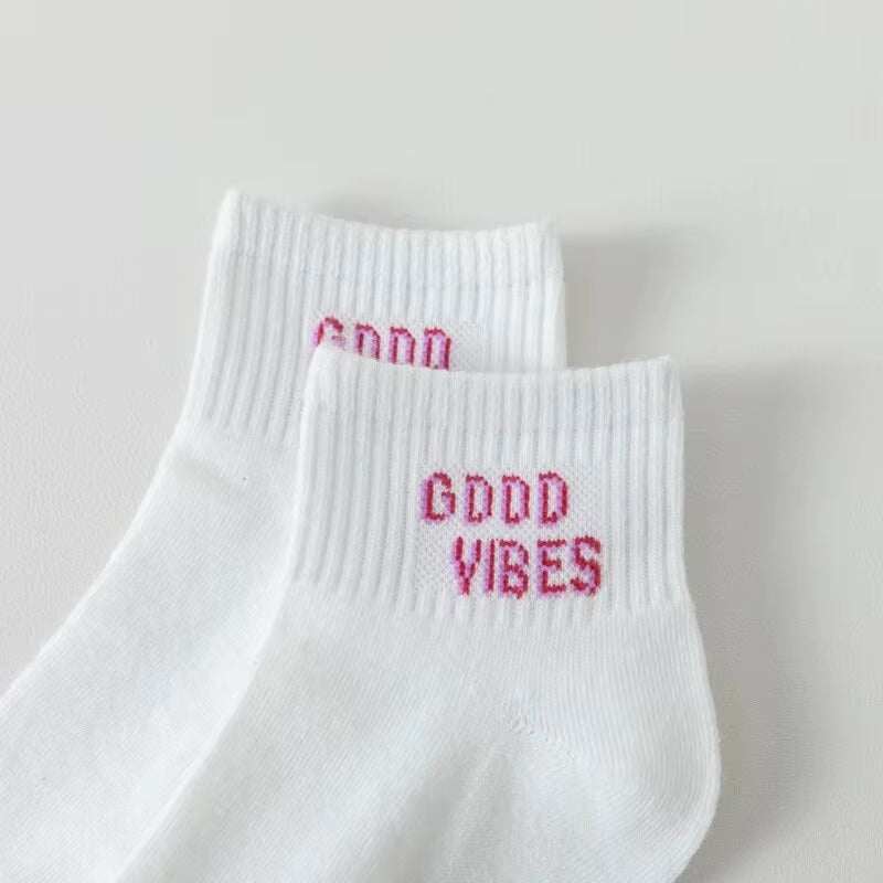 White ankle socks with "Good Vibes" text, fun smiling face design for women.