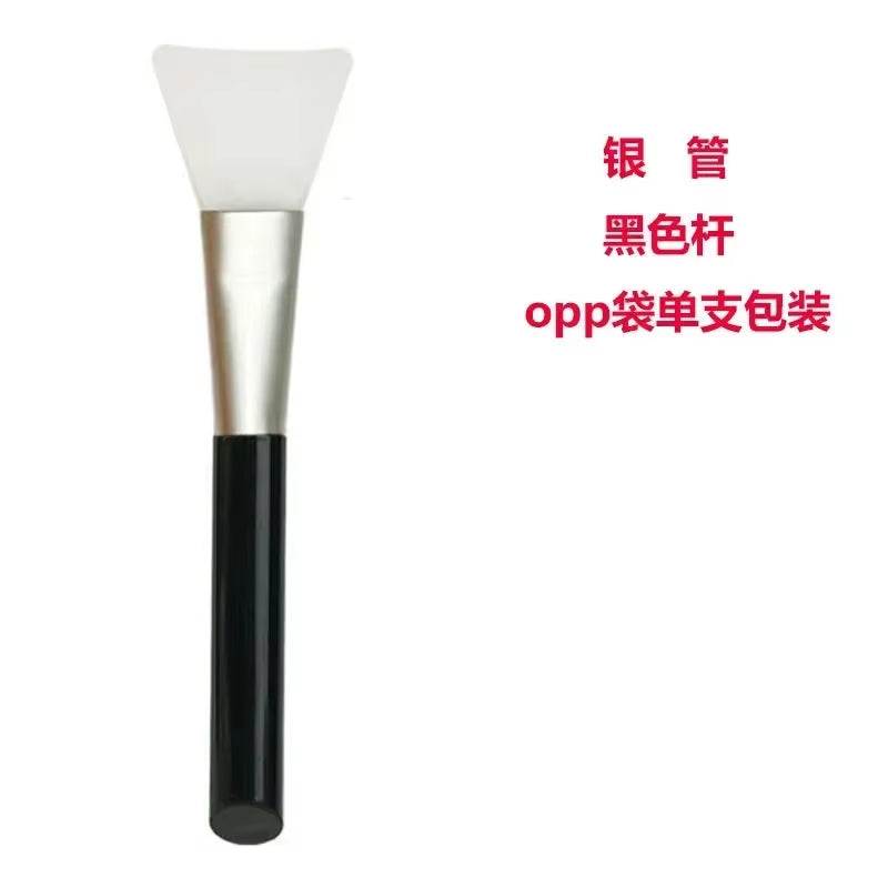 Silicone facial mask brush with soft, flexible head and black handle.