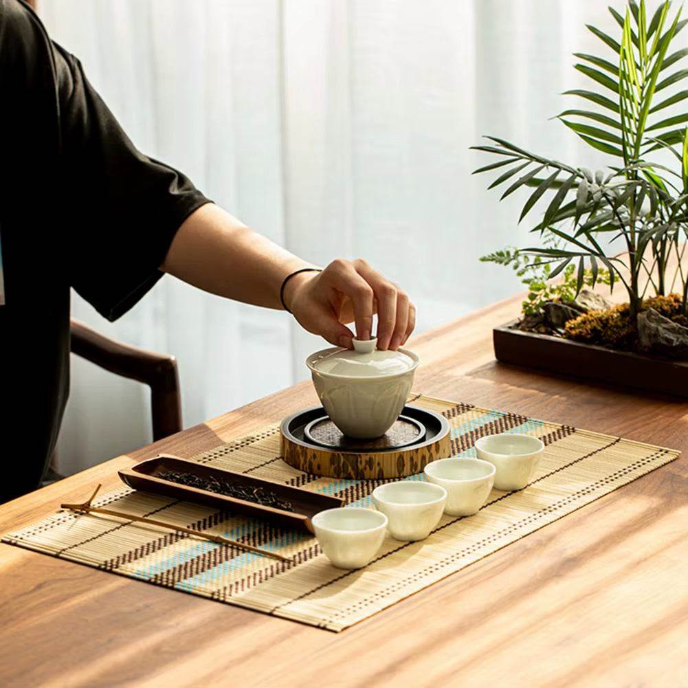Decorative waterproof lightweight bamboo table mat and coasters set with tea accessories on wooden table