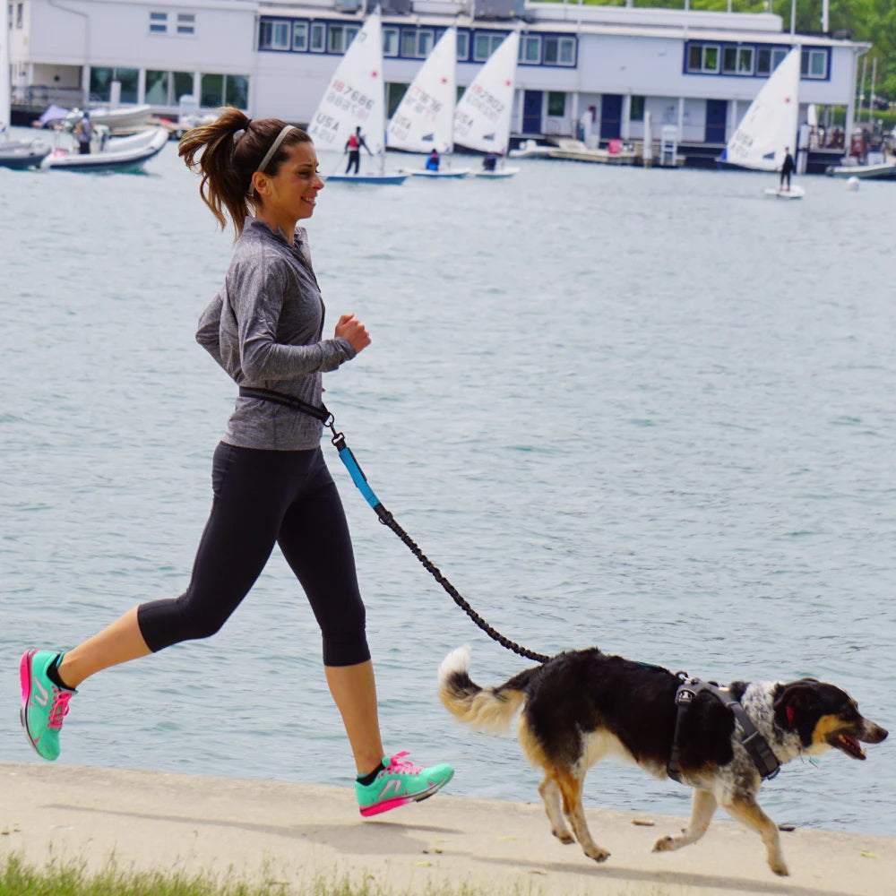 Woman jogging with her dog using an adjustable hands-free dog leash by the water