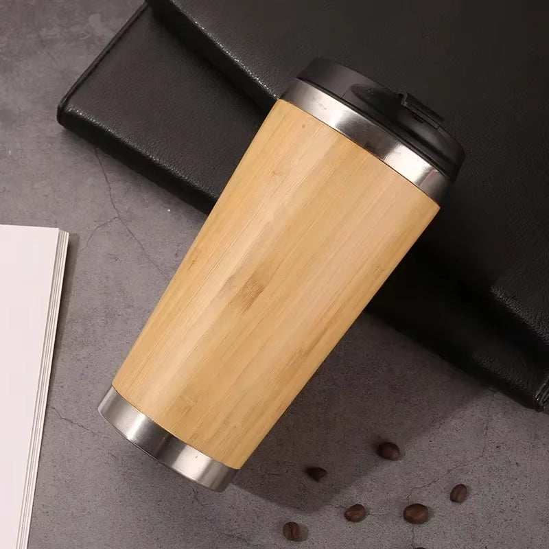 Eco-friendly bamboo stainless steel travel cup with flip-top lid, designed for hot or cold beverages.