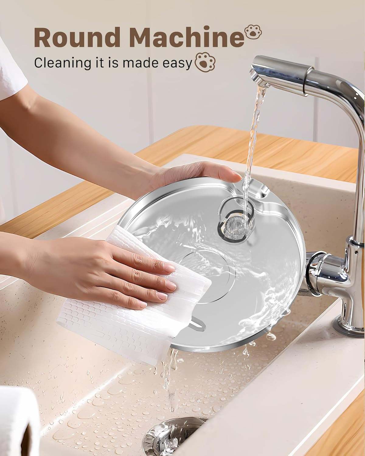 Person rinsing a removable stainless steel bowl under a kitchen faucet for a pet stainless steel water fountain.
