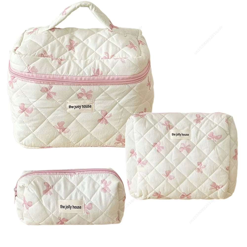 Quilted floral makeup bag set with cotton construction and bow accents.