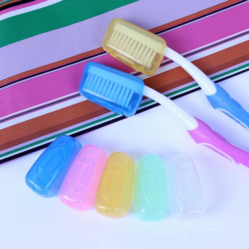 Portable travel toothbrush tubes with colorful protective caps next to striped fabric background.