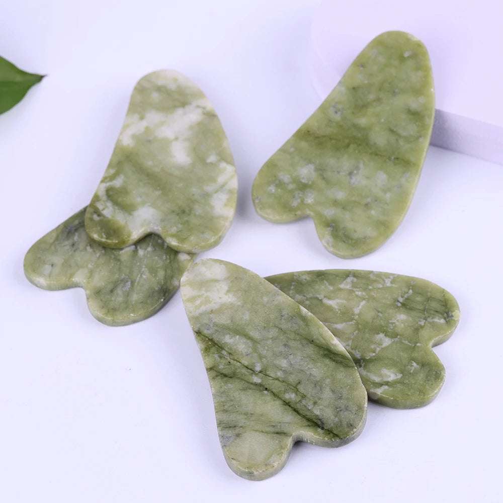 Natural jade Gua Sha scrapers for face massage and skincare therapy.