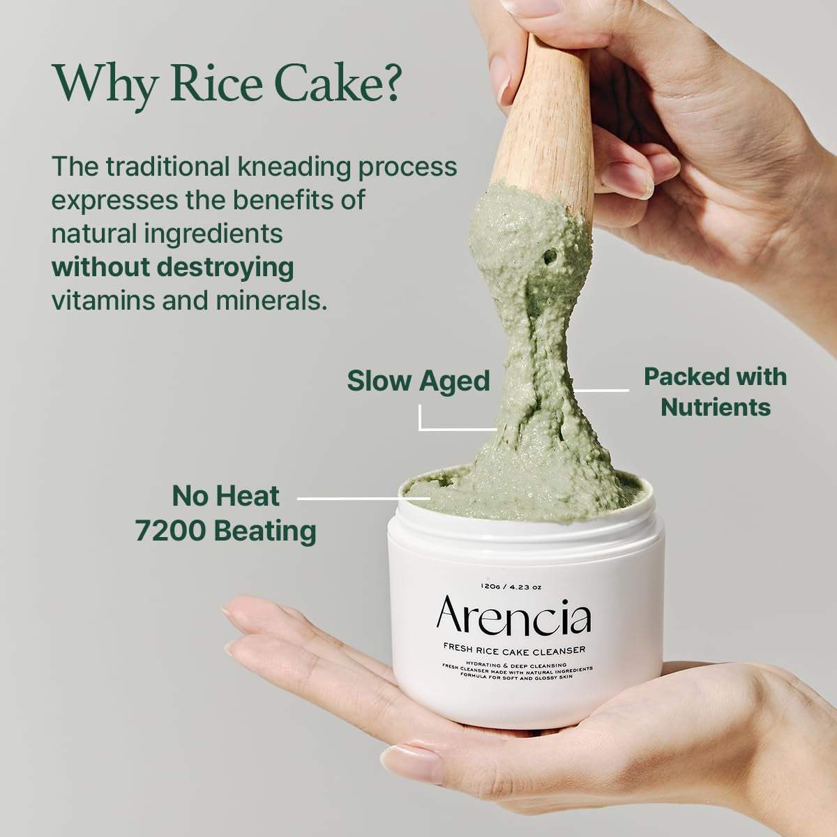Hand holding open jar of Arencia Fresh Rice Cake Cleanser being scooped with a wooden spatula, showcasing thick green face cleanser mask texture.