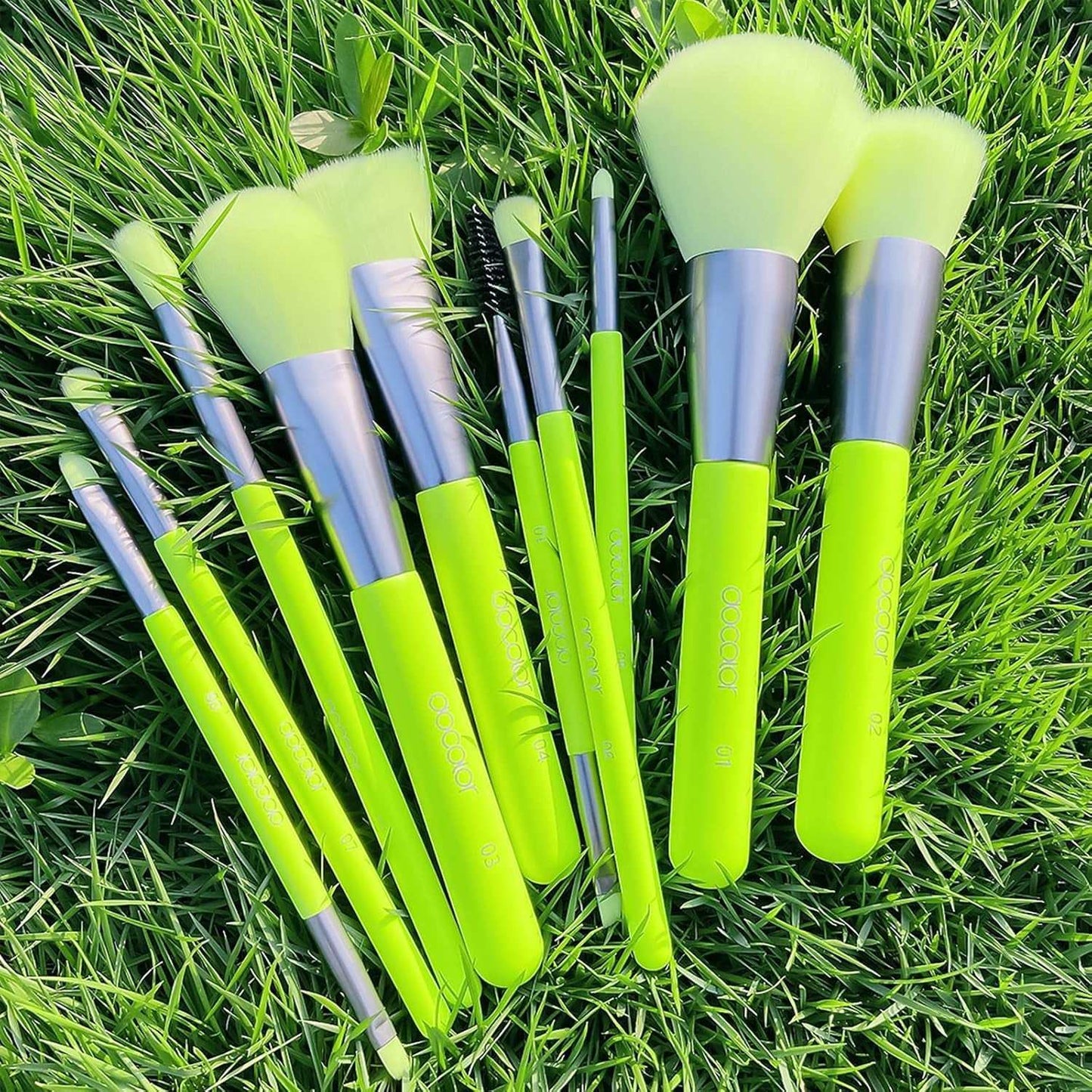 Neon green makeup brush and sponge set on grass, featuring 10 brushes and 3 pea pod sponges for vibrant looks.